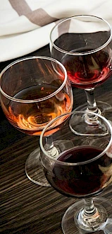 The image shows a selection of wine glasses accompanied by a plate of charcuterie with meats, cheeses, olives, and breadsticks.